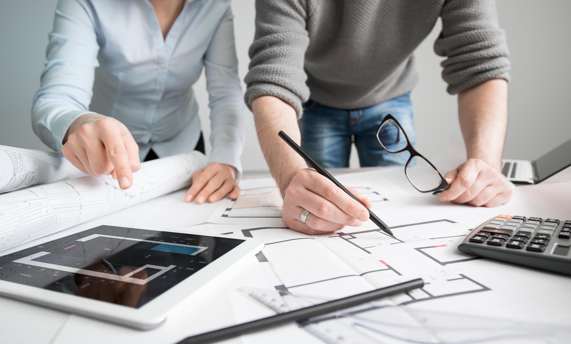 two people leaning over the plan of the bathroom